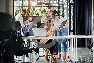 Purposeful female office manager signing the financial document at her workplace which give her female secretary Stock Photo