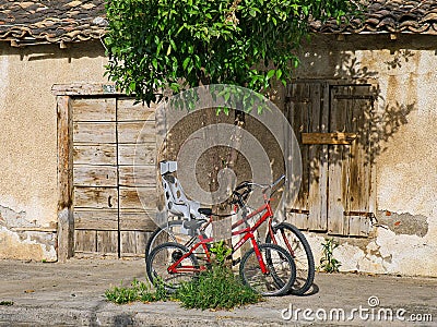 Pushbikes Resting on Orange Tree Outside old Greek House Editorial Stock Photo