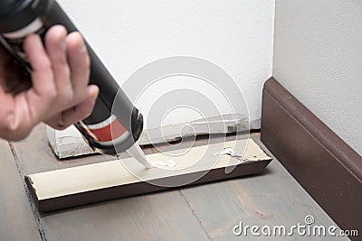 Pushing glue on the wooden baseboard Stock Photo