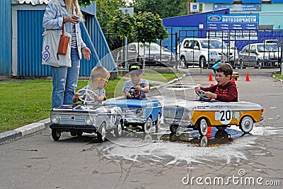 Children driving Soviet pedal cars `Moskvich` at the festival `Retrosummer` in Pushkino Editorial Stock Photo