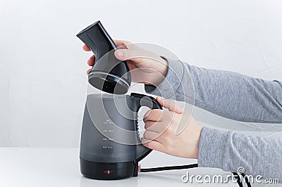 Puts a replaceable garment steamer head in the hand of Caucasian woman. White background Stock Photo