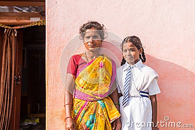 PUTTAPARTHI, ANDHRA PRADESH, INDIA - JULY 9, 2017: Indian woman in sari and girl in school uniform. Copy space for text. Close-up. Stock Photo