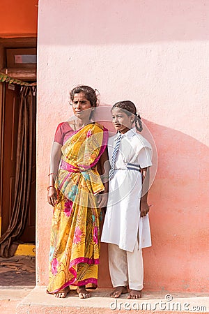 PUTTAPARTHI, ANDHRA PRADESH, INDIA - JULY 9, 2017: Indian woman in sari and girl in school uniform. Copy space for text. Vertical. Editorial Stock Photo