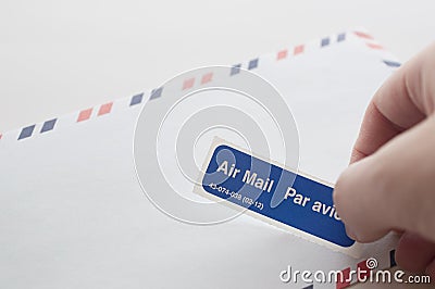 Putting air mail tag on envelope Stock Photo
