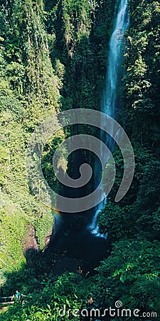 Putuk Truno Waterfall Indonesia: a waterfall with a beautiful rainbow Editorial Stock Photo