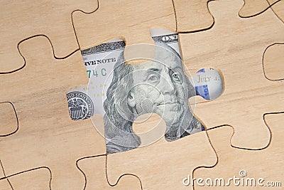 A puzzle of wood and a hundred dollars of a banknote. portrait of american president Stock Photo