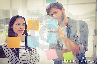 Puzzled business team looking post its on the wall Stock Photo