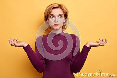 Puzzled hesitant blonde woman shrugs shoulders, being clueless and uncertain. Stock Photo