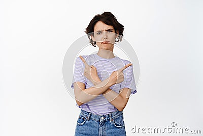 Puzzled upset girl, frowning and sulking woman pointing sideways, unfair thing, complaining and showing left right Stock Photo