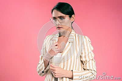 Puzzled, worried young business woman in suit look stressed holding side of her jacket collar looking down wearing eye Stock Photo