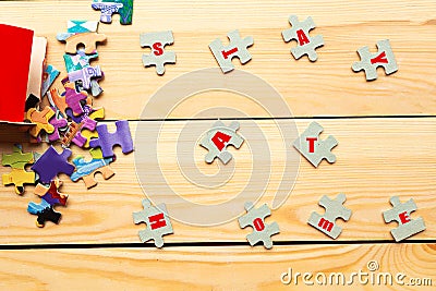 Puzzles with the text Stay Home on wooden background. Stock Photo