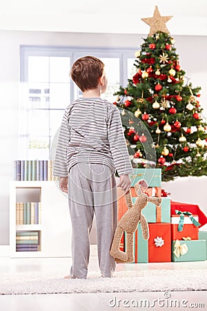 Pyjama boy with toy at christmas tree Stock Photo