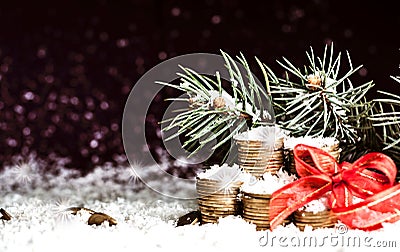 Pyramid of coins and the coins scattered over in the snow Stock Photo
