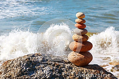 Pyramid of colorful, balanced stones on the summer sea background. Concept of harmony and balance Stock Photo