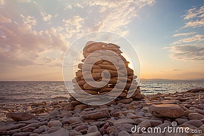 Pyramid of stones on the beach at sunset, beautiful seascape, rest and seaside vacation concept Stock Photo