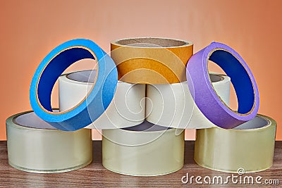 Pyramid of adhesive tape for various purposes, orange background Stock Photo