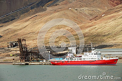 Ship unloads at the pier of the abandoned Russian arctic settlement Pyramiden, Norway. Editorial Stock Photo