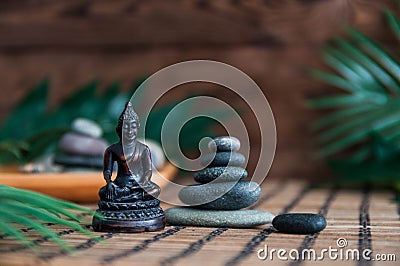 Pyramids of gray zen stones with green leaves and Buddha statue. Concept of harmony, balance and meditation, spa, massage, relax Stock Photo