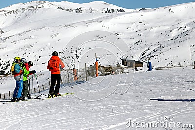 PYRENEES, ANDORRA - FEBRUARY 13, 2019: Group skiers stand at the beginning of the ski slope and look down. Editorial Stock Photo