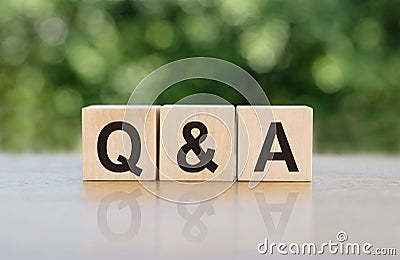 Q&A - question and answer, word written on wooden blocks. The text is written in black letters and is reflected in the mirror Stock Photo