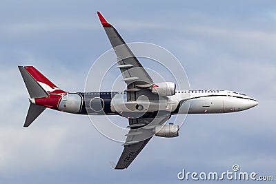 Qantas Boeing 737 aircraft VH-XZJ named Mendoowoorrji wearing a special aboriginal themed livery performing a flypast over Melbour Editorial Stock Photo