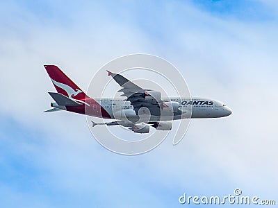 QANTAS A380 flying through blue and cloudy sky. Editorial Stock Photo