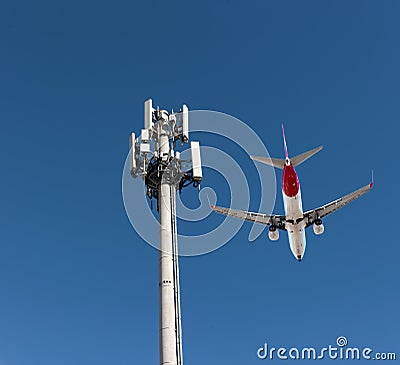 QANTAS jet over 5G communications tower Editorial Stock Photo