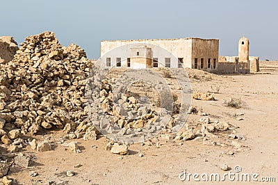 Qatar. The desert at coast of Persian Gulf. Abandoned mosque with minaret. Deserted village. Pile of stones Stock Photo