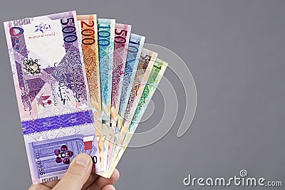 Qatari money in the hand on a gray background Stock Photo