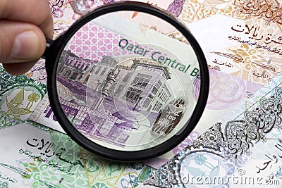 Qatari riyal in a magnifying glass Stock Photo