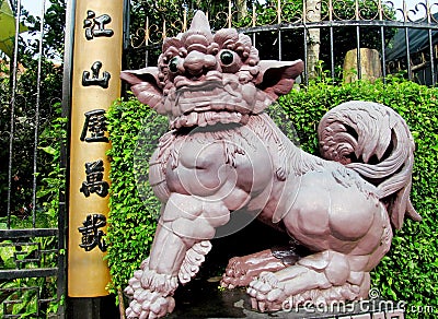 Qilin asian mythological statue near hieroglyphic column Stock Photo