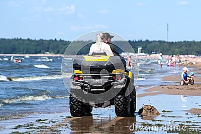 Quad bike on the beach on a dusty yellow background. Landscape blue background. Seascape. Summer landscape in the background. Editorial Stock Photo