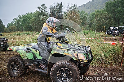 Quad rider jumping on a muddy forest trail Editorial Stock Photo