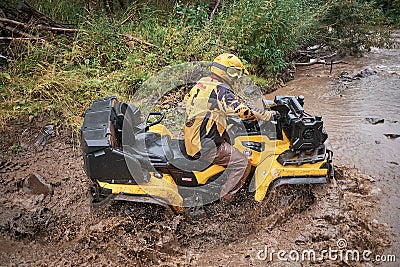 Quad rider jumping on a muddy forest trail Editorial Stock Photo