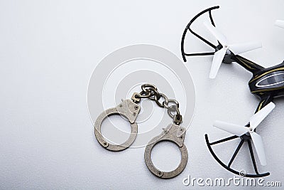 Quadcopter handcuffs white leather background Stock Photo