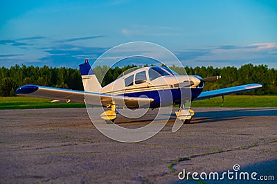 Quadruple aircraft parked at a private airfield. Rear view of a plane with a propeller on a sunset background. Stock Photo