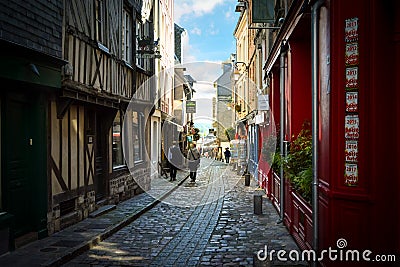 Quaint street in the Normandy town of Honfleur France with Saint Catherine`s church in the distance on a sunny day in early autumn Editorial Stock Photo