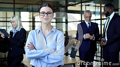 Qualified female analyst folded arms smiling camera, business career, work Stock Photo