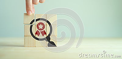 Quality warranty concept. Standardization, ISO. Hand placed wooden cubes Stock Photo