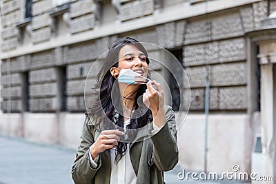 Quarantine is over concept. Woman taking off mask outdoor. We are safe. Coronavirus ended. We won. No more quarantine. Breathe Stock Photo