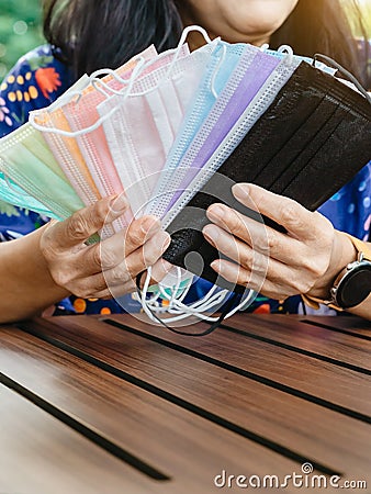 Quarantined woman choose colorful surgical masks to wear to prevent the spread of the CoronavirusCovid-19 Beautiful multi Stock Photo