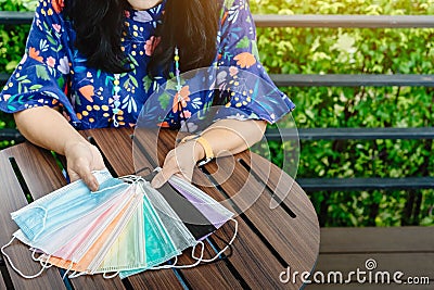 Quarantined woman choose colorful surgical masks to wear to prevent the spread of the CoronavirusCovid-19 Beautiful multi Stock Photo