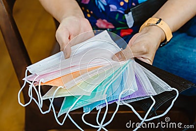 Quarantined woman choose colorful surgical masks to wear to prevent the spread of the CoronavirusCovid-19 Beautiful multi Stock Photo