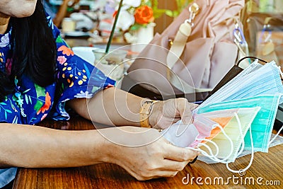 Quarantined woman choose colorful surgical masks to wear to prevent the spread of the CoronavirusCovid-19 Beautiful multi Stock Photo