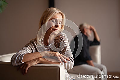 Quarrel in a mature family, betrayal and divorce. Upset older wife with her husband at home. Difficulties in the relationship of Stock Photo