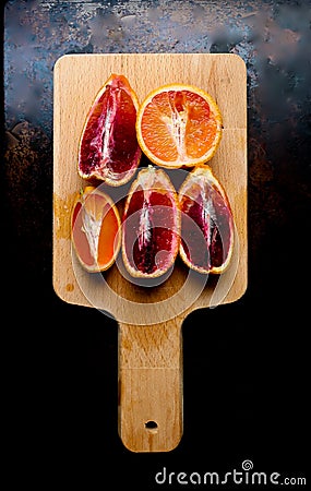 Quartered blood oranges on a wood cutting board Stock Photo
