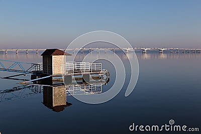 Quay afloat reflected on mirror water surface Stock Photo