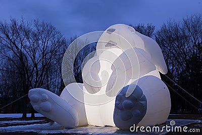 Twilight low angle view of glowing giant inflatable rabbit from the artist Amanda Parerâ€™s Intrude Family Editorial Stock Photo