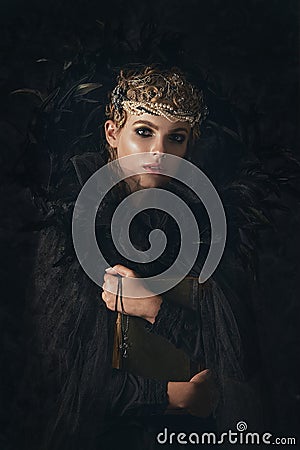 Queen of darkness in black fantasy costume on dark gothic background. High fashion beauty model with dark makeup. Stock Photo