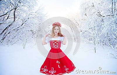 Queen in a red crown among the winter forest. Lovely girl in a Stock Photo